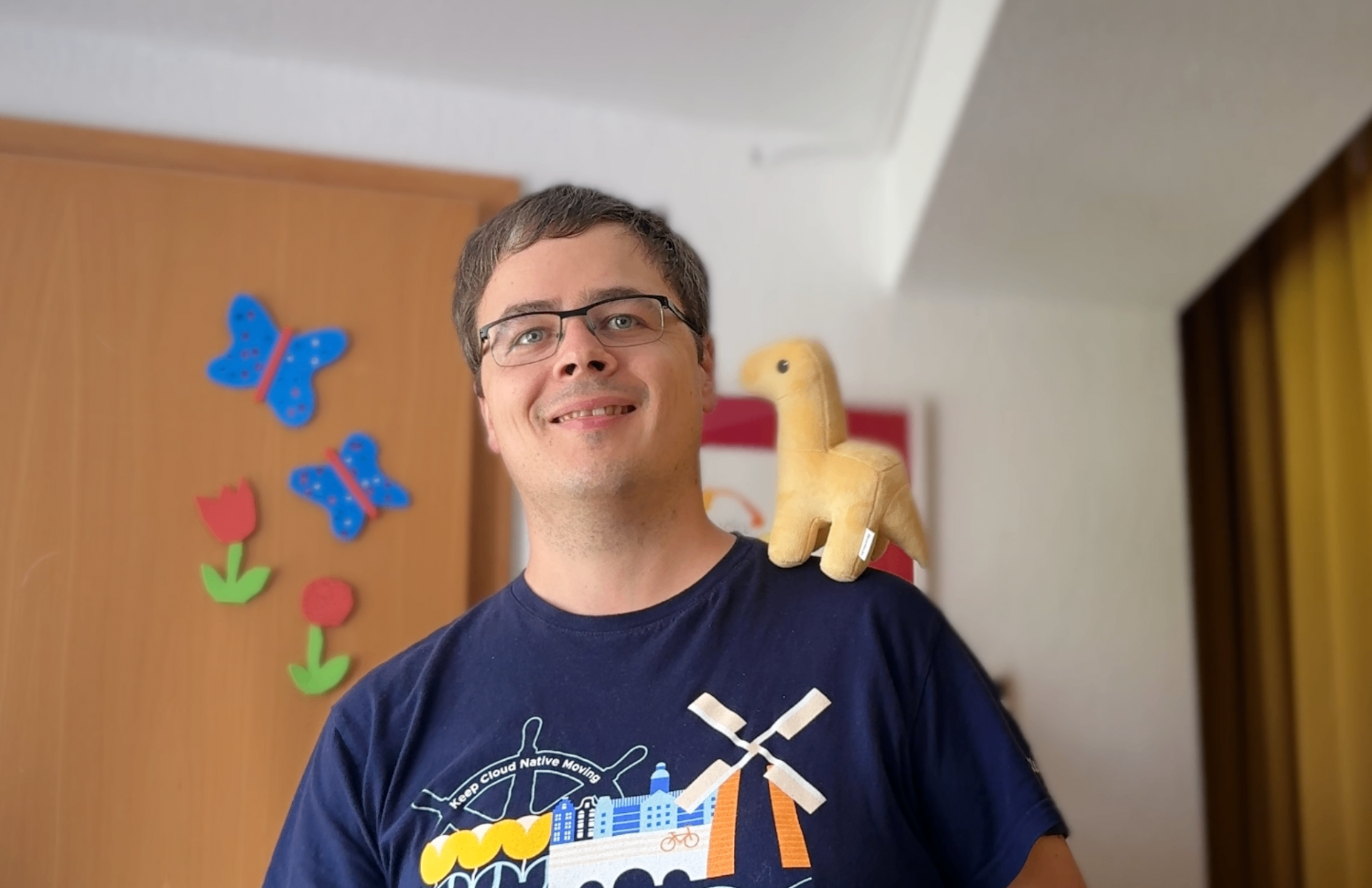 Severin Neumann smiling with a plush Bronto dinosaur on his shoulder